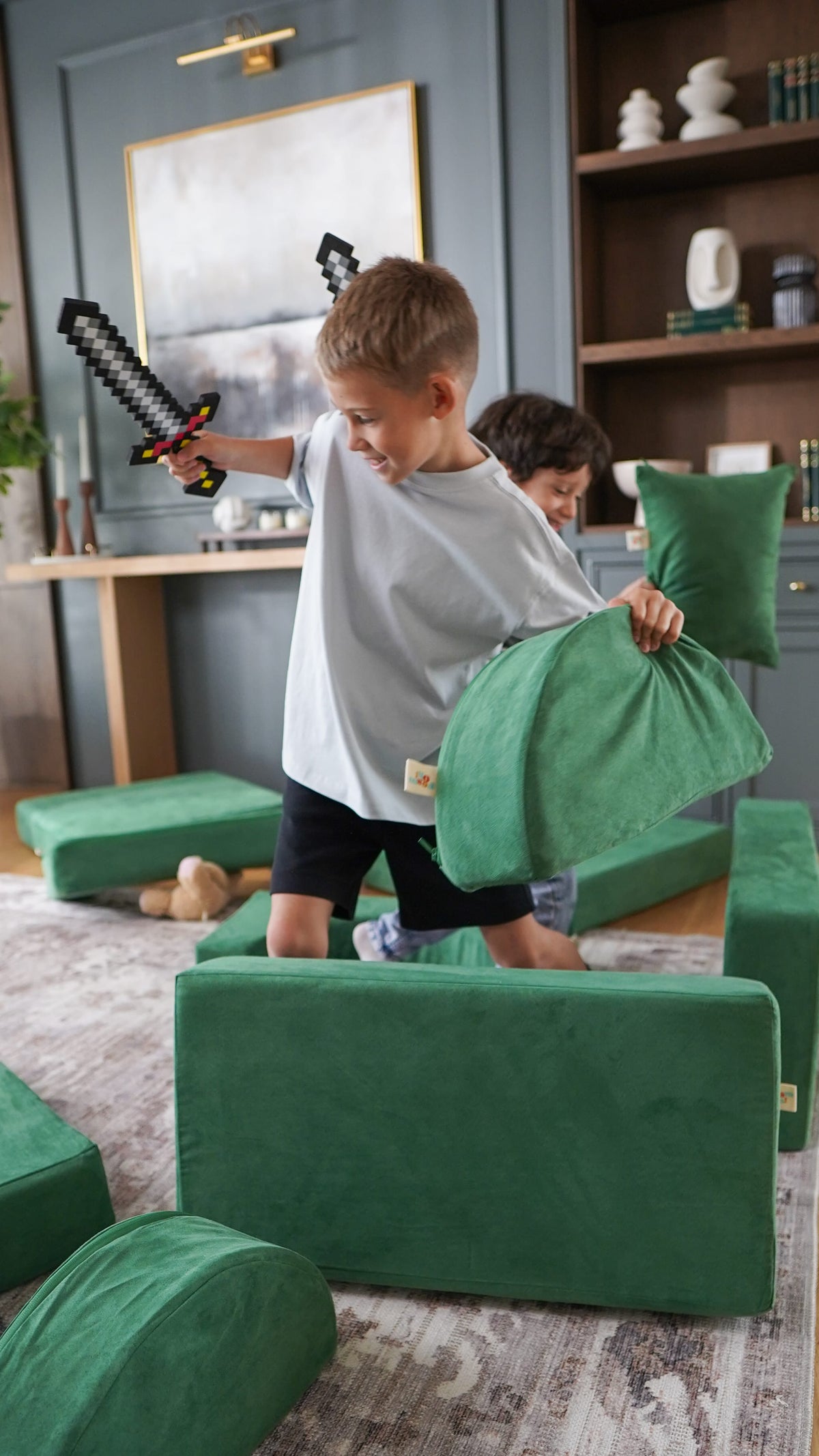 Boy with a toy sword using a green FoamOh play couch piece as a shield in a pretend battle arena